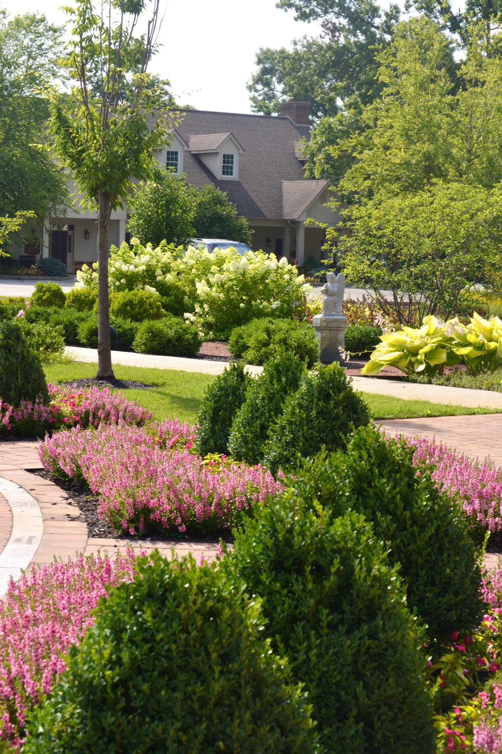 Highlighted beds and trimmed shrubs on an evening-lit property by Plant Studio Landscape near Muncie, Indiana