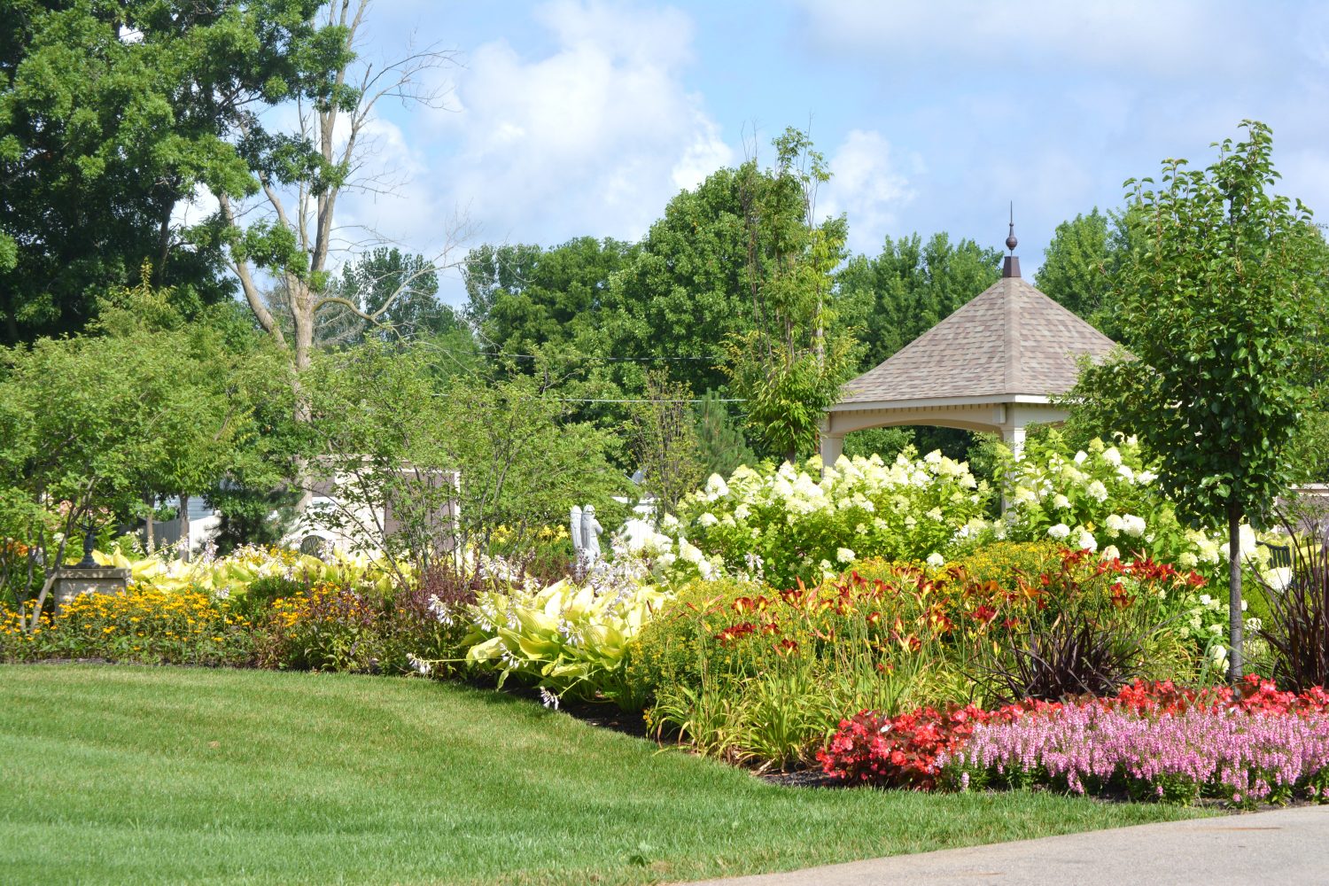 Perennial-driven flower bed by Plant Studio Landscape filled with summer workhorse blooms